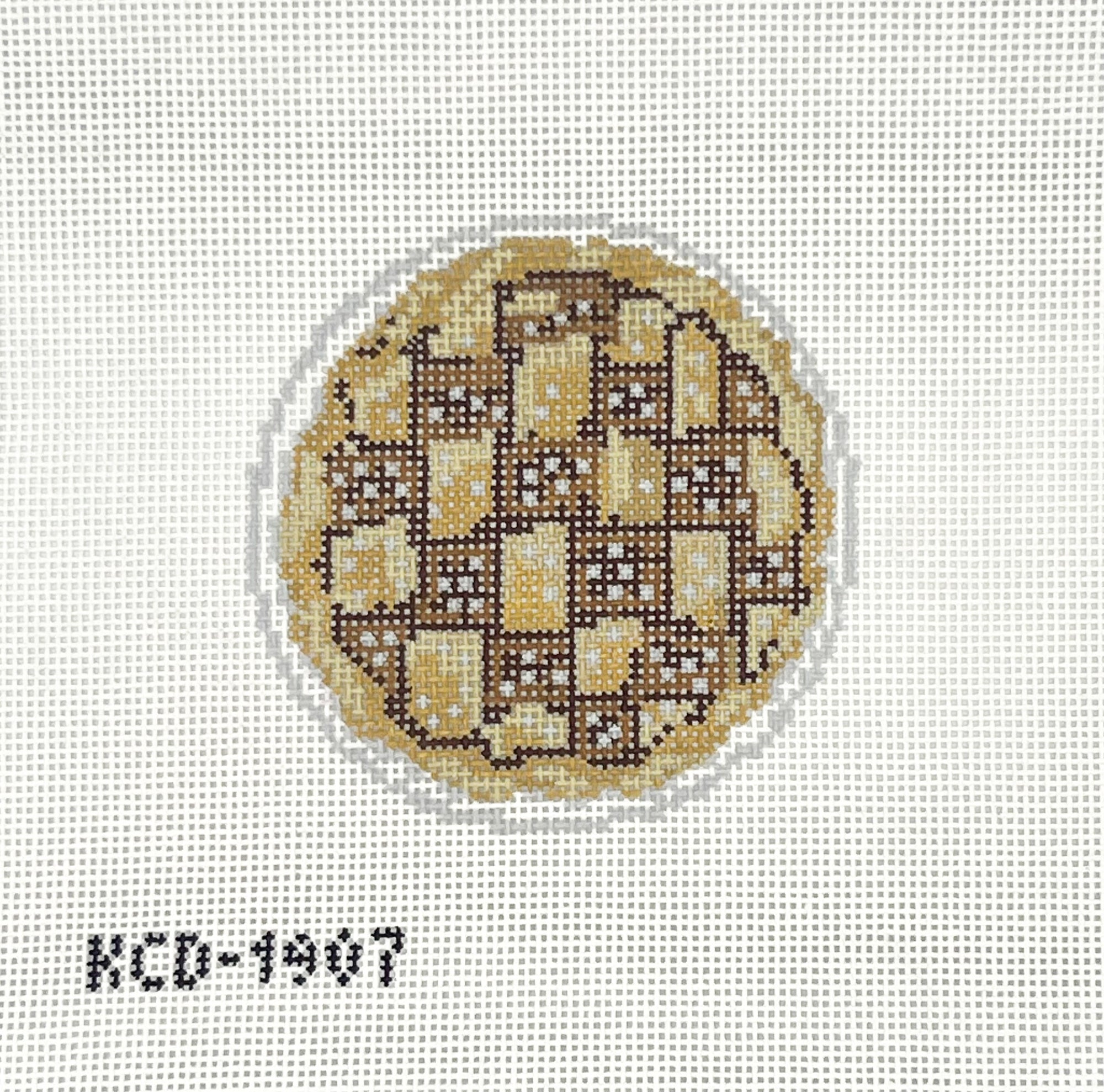 Circular brown pie needlepoint design on a white canvas