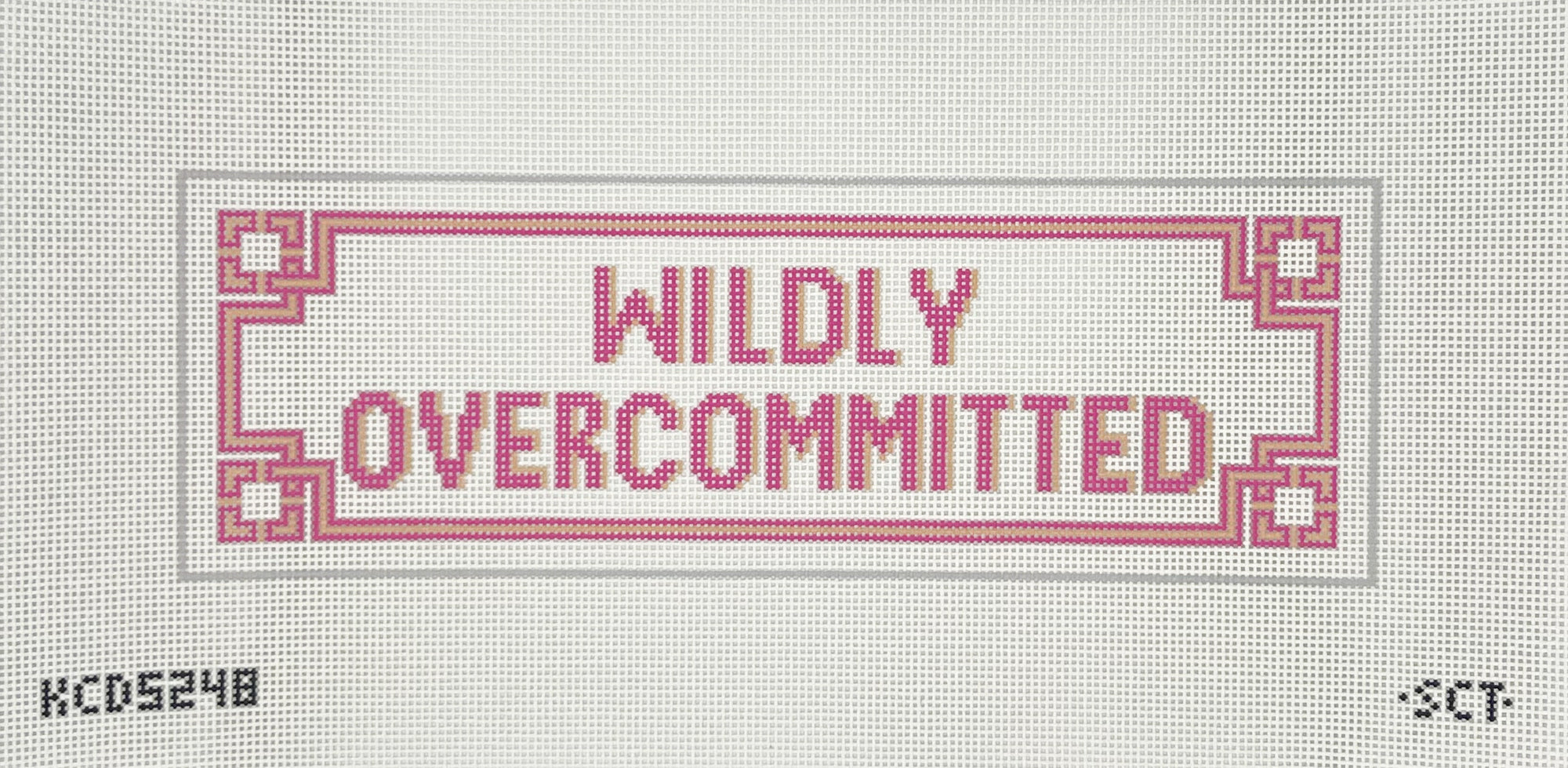 Pink text that says widly overcommitted on a rectangle needlepoint canvas