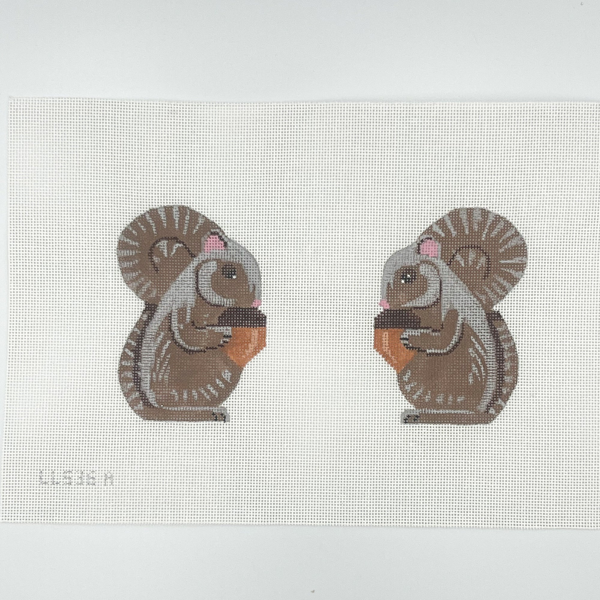 Two cartoon-style squirrels needlepoint design on a white canvas
