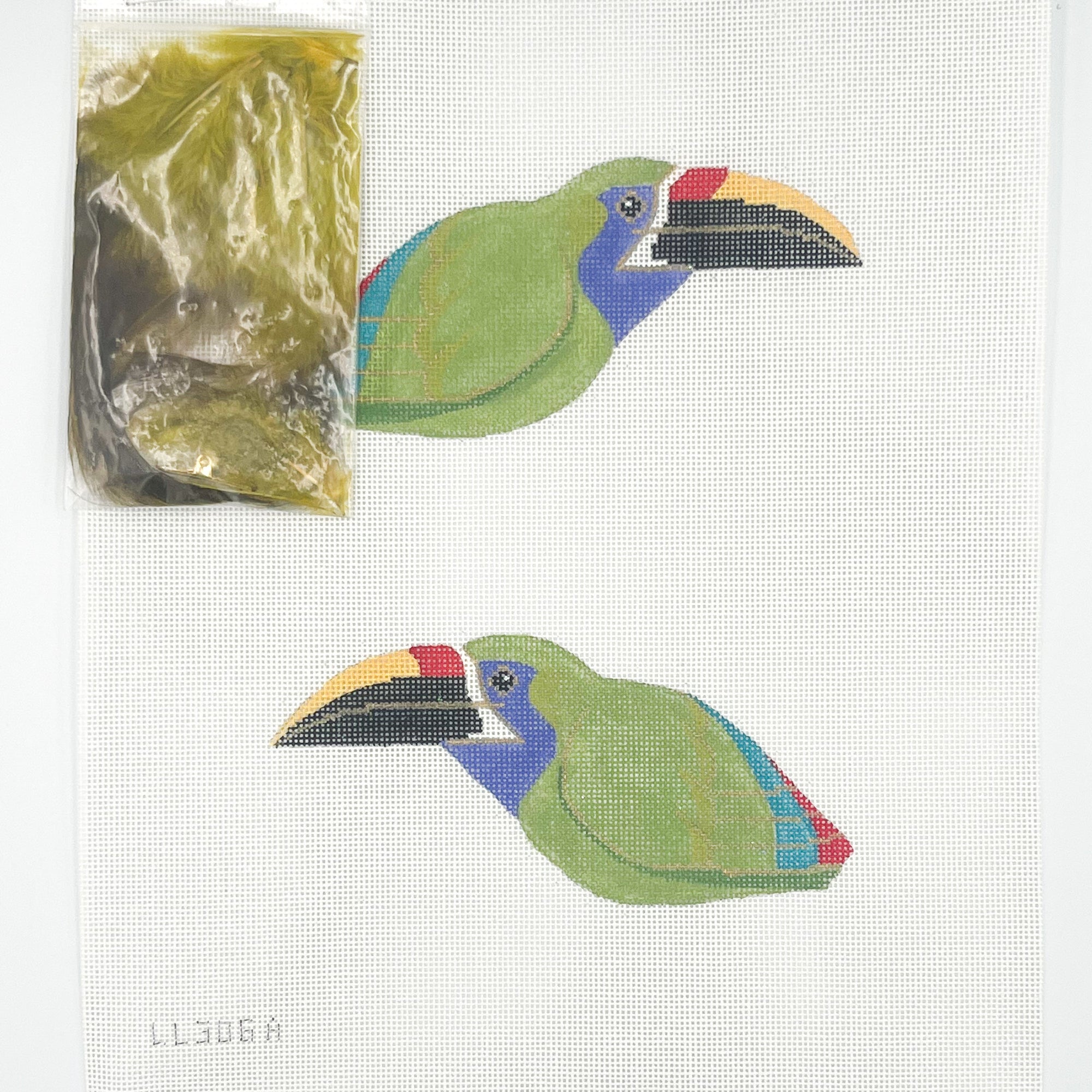 Two colorful toucan needlepoint design on a white background with a clear plastic bag.