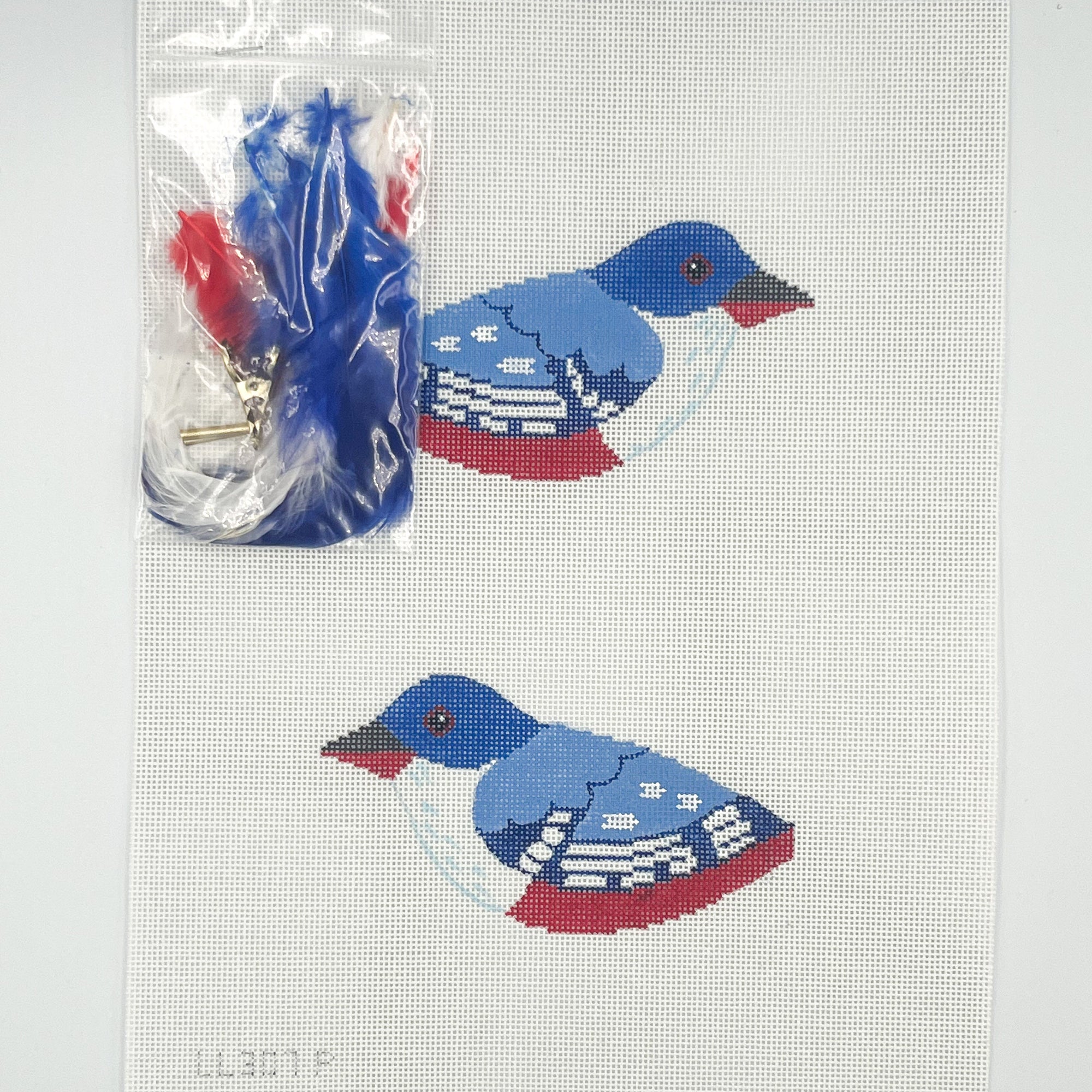 Two blue and red bird needlepoint design on a white canvas