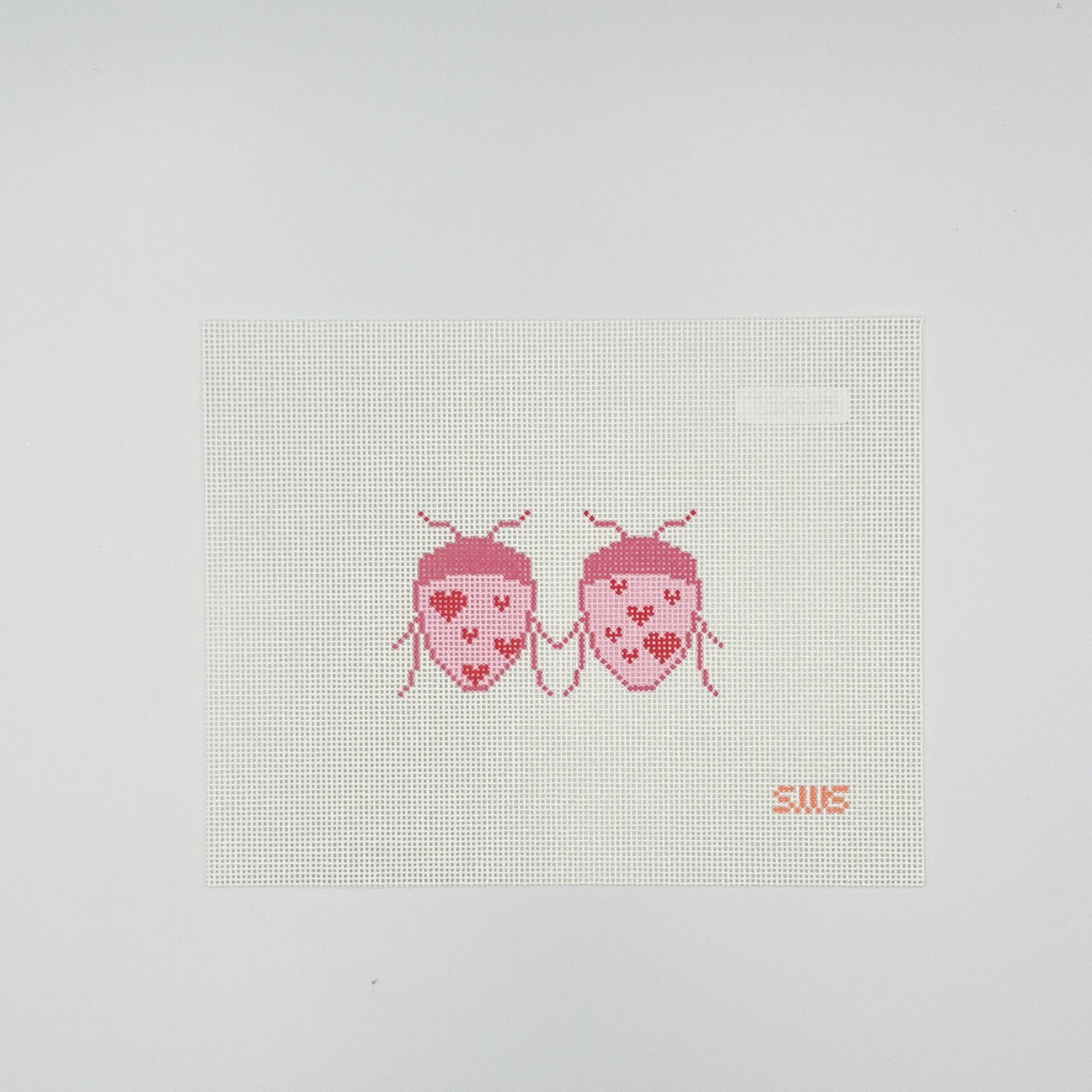 Red and pink lady bugs with hearts design on white needlepoint canvas