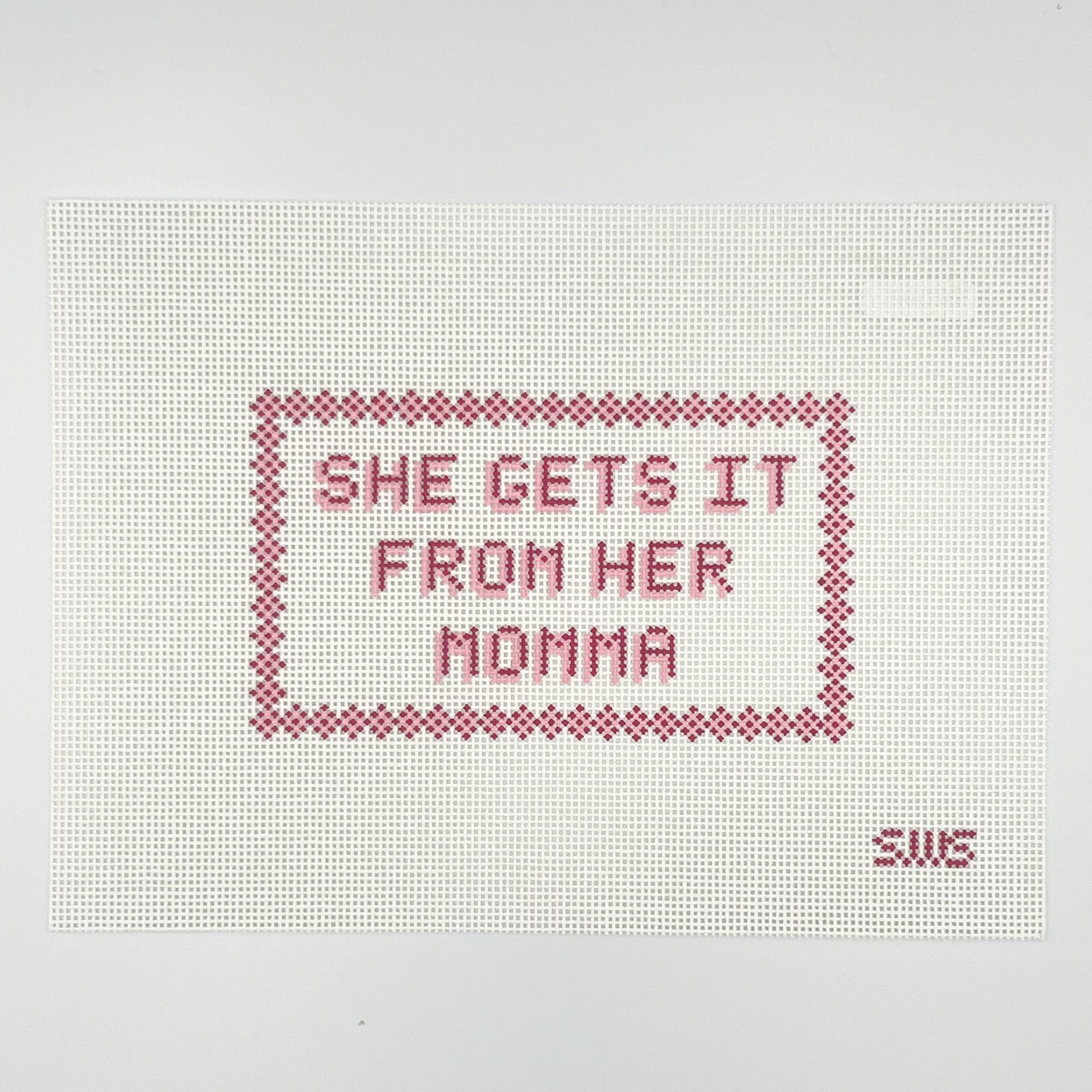 Needlepoint canvas design with pink border and text that says she gets it from her momma