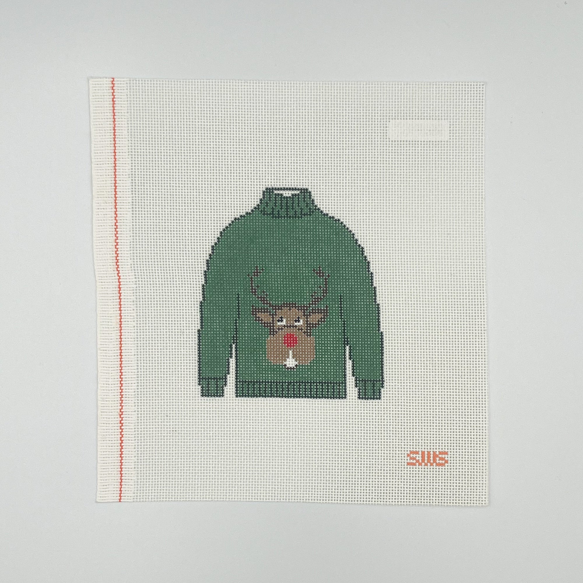 Needlepoint design with green sweater with reindeer on it on a white canvas