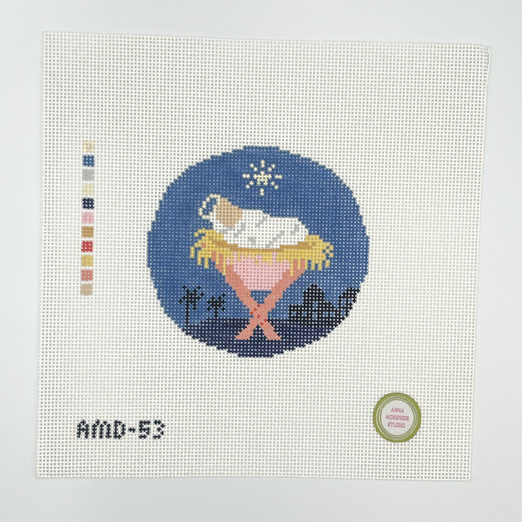 Needlpoint design of a nativity scene on fabric with color swatch and label.