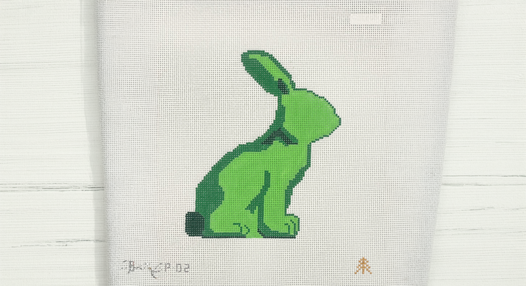 Green rabbit design on a white fabric background